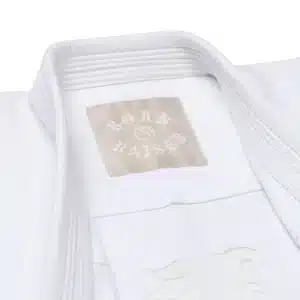 Close view of kimono collar highlighting light-gold “Born Raised” woven label on the Shoyoroll x Born x Raised gi.